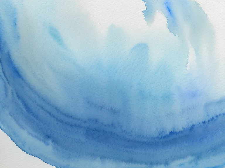 Detalle de papel de 300g con relieve blanco y una aguada de acuarela azul